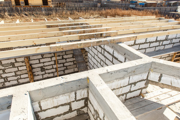 Under construction house walls made from white aerated autoclaved concrete blocks. Woods elements and components of the construction of roof. Ceiling beams of natural eco-friendly materials. top view