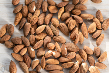 on a light wooden background lies almonds