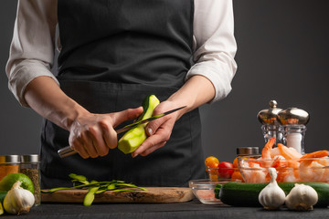 Chef slices zucchini for cooking shrimp, seafood, healthy and delicious Asian oriental cuisine