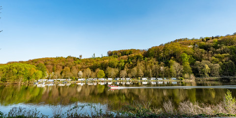 Fototapeta premium Panorama Spiegelung Campingplatz in Essen Kettwig in der Ruhr im Frühling
