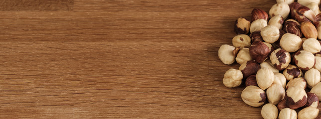 Banner: Geröstete Haselnüsse auf einem Holz-Hintergrund