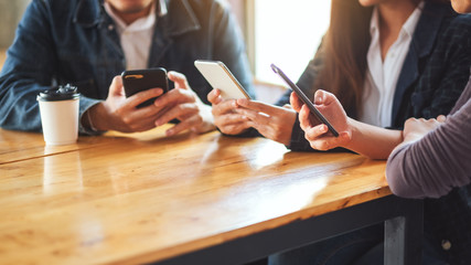 Group of people using and looking at mobile phone while sitting together
