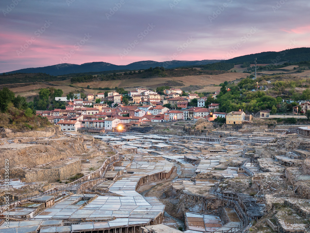 Wall mural salt ponds and the illuminated village of salinas de añana at sunrise, in alava, basque country, spa