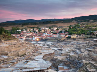 Salt ponds and the illuminated village of Salinas de Añana at sunrise, in Alava, Basque Country,...
