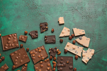 Sweet chocolate with nuts on color background