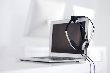 Call center and communication support, customer service help desk. VOIP headset on laptop computer