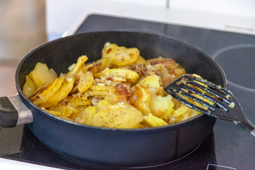 Bratkartoffeln in der Pfanne steht auf dem Herd zum Abendessen frisch zubereitet