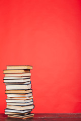 many stacks of educational books to study in the college library on a red background