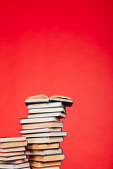 many stacks of educational books to study in the college library on a red background