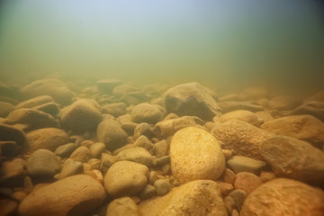 stones at the bottom underwater landscape, abstract blurred under water background