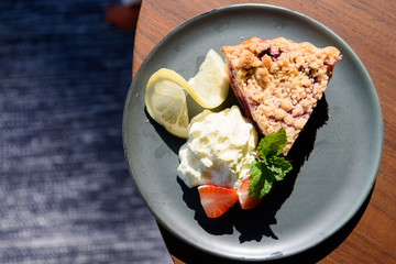 Blueberry Pie Delicious, Served with whipped cream and strawberries, On wooden table top.