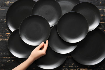 Woman at table with clean plates, top view