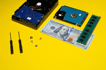 hard drives and replacement tools with dollars and memory on a yellow background