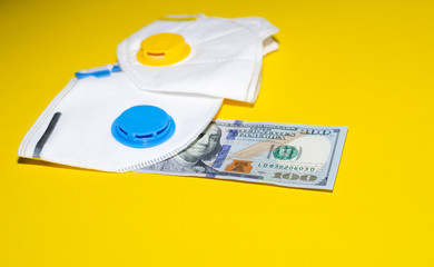 respirators and money on a yellow background