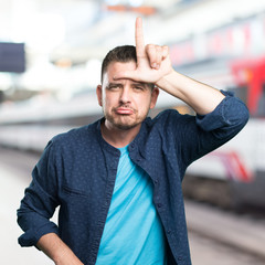 Young man wearing a blue outfit. Doing looser gesture.