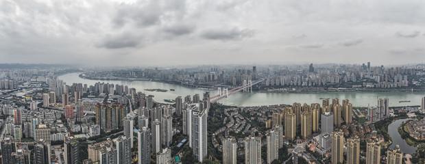 Naklejka premium Aerial pano pano drone shot of populated residence buildings alng Yangtze river in Chongqing, southwest China metropolis