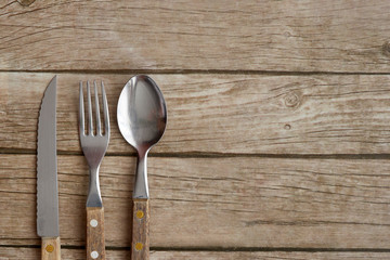 spoon, knife and fork with a wooden handle