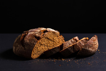 Loaf of rye yeast-free bread on a black background.