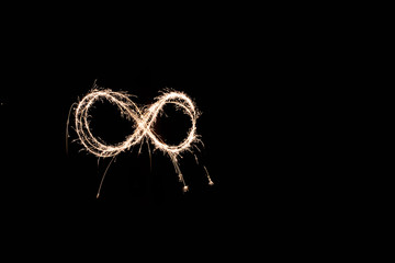 handwritten infinite loop, light painting experiment with bulb exposure, at night. black background
