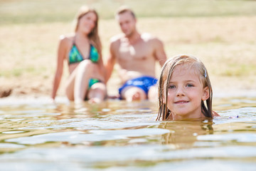 Fototapeta premium Kleines Mädchen lernt Schwimmen im Badesee