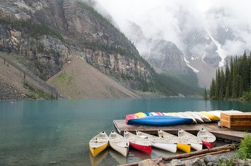 Fototapeta na wymiar Colourful Canadian wooden canoes on lake in British Columbia, Canada