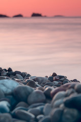 Pretty red sunset over a pebble beach in Menorca, Spain