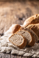 Portrait close up of slices of crusty bread leaned against the loaf on a vintage cloth and rustic...