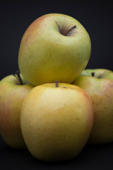 four apples on a black background
