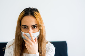 Blonde girl with mask isolated at home during quarantine. Portrait with mask. Coronavirus pandemic.