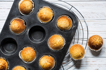 cupcakes inside a baking tray on a rustic white wooden board