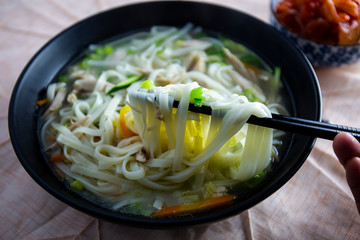 Korean chicken noolde soup which is called Dalgkalgugsu with Kimchi