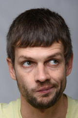 Fototapeta premium Close-up portrait of a pensive man twisting his mouth, European appearance