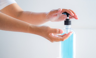 Hand of woman holding by alcohol gel from pump bottle. protect coronavirus (covid-19)