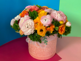 Bright colorful pink yellow orange persian asian buttercup ranunculus asiaticus bouquet flowers in round box