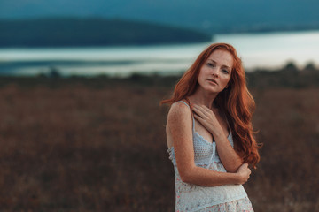 Fototapeta premium Incredible young woman with long curly hair and freckles face.