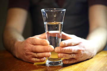 mens hands holding a glass
