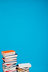 many stacks of educational books to teach in the library on a blue background
