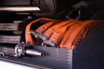 orange hose with a metal sprayer in a fire truck. fire truck in standby mode. fire fighting...