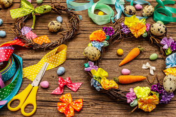 Hand crafted Easter wicker wreath with quail eggs and handmade flowers. Set of materials and tools for needlework. Stay at home concept. Festive Easter background