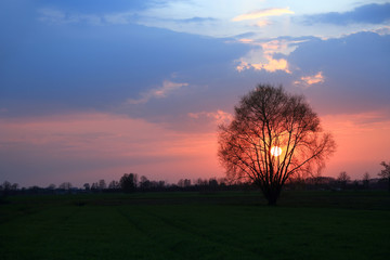 Kolorowy zachód słońca nad obszarem wiejskim, kolorowe chmury.