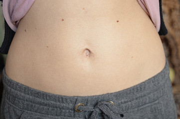 belly of a young girl with a belly button closeup at home