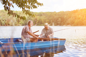 Vater und Sohn angeln im Boot auf See