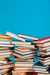 many stacks of educational books to teach in the library on a blue background