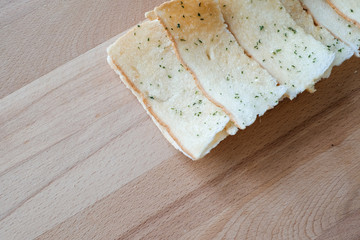 Homemade ,Fresh baked sliced garlic bread on a rustic wooden cutting board