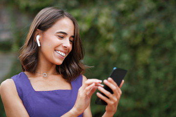 Young woman listening to music via earphones outdoor