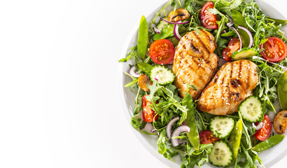 Top view healthy salad with grilled chicken topped with sesame seeds, rocket, spring peas, cherry tomatoes, sliced cucumber, grilled mushrooms and red onion.