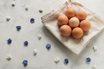 Easter eggs on a white dish-cloth surrounded with small flowers