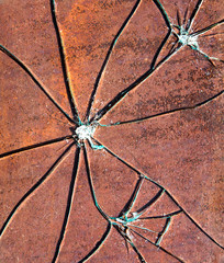 Broken glass on a dark background of ductile iron, cracks, scratches