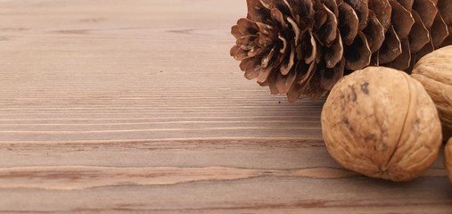walnuts on wooden background, pine cones on wooden table background