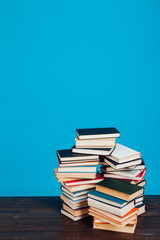 many stacks of educational books to teach in the library on a blue background